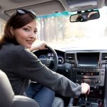 Portrait of beautiful young woman in the new car  - outdoors