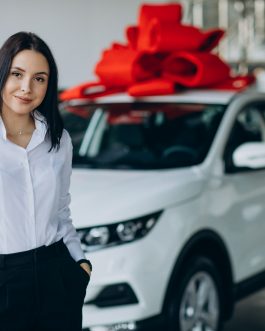 Woman by the car with big red bow